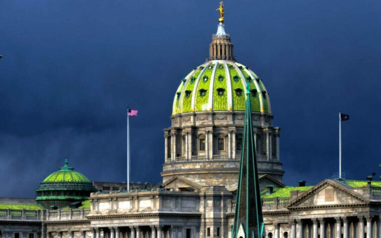 Pennsylvania state capitol building with dark clouds behind it and dramatic light