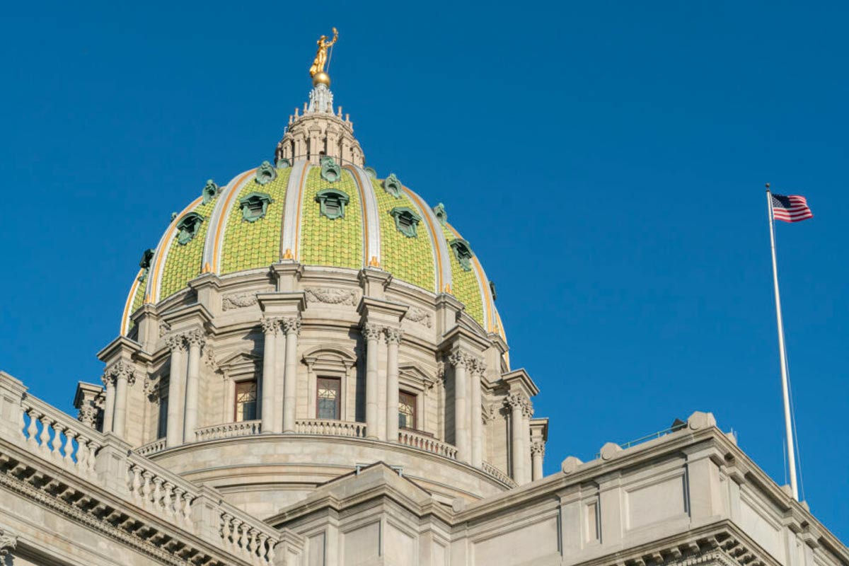 View looking upward at the dome of the PA Capitol against a bright blue sky